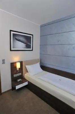 Ein Bett oder Betten in einem Zimmer der Unterkunft Hotel Bergischer Hof